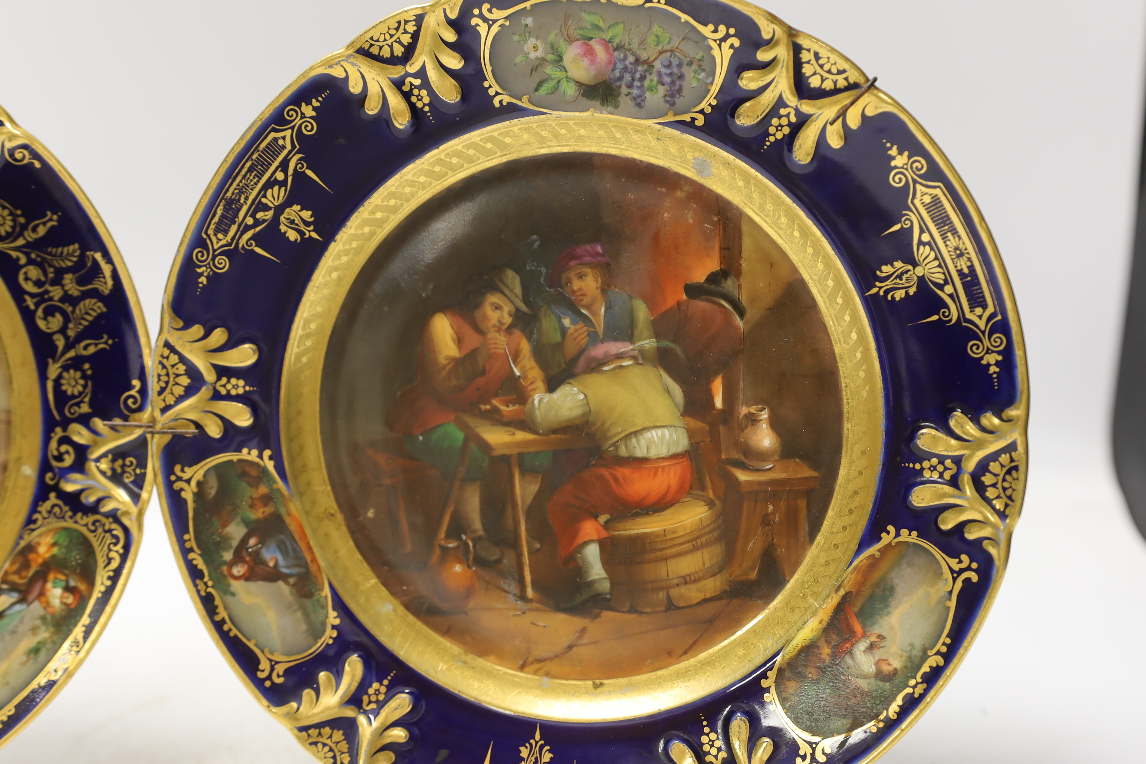 Two 19th century Vienna style plates, with painted central cartouche tavern scenes after Teniers, 22cm diameter